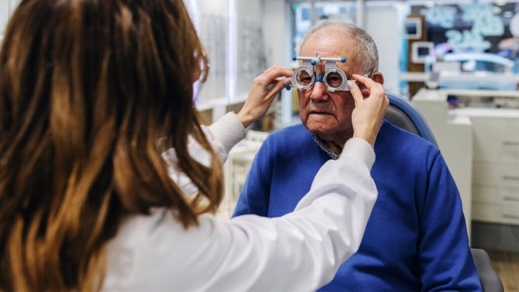 A technician checks the eyesight of an older man
