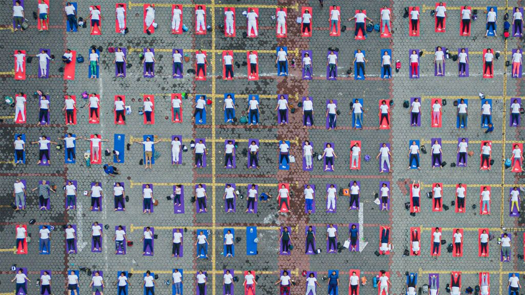 Bird's eye view of many people on yoga mats.