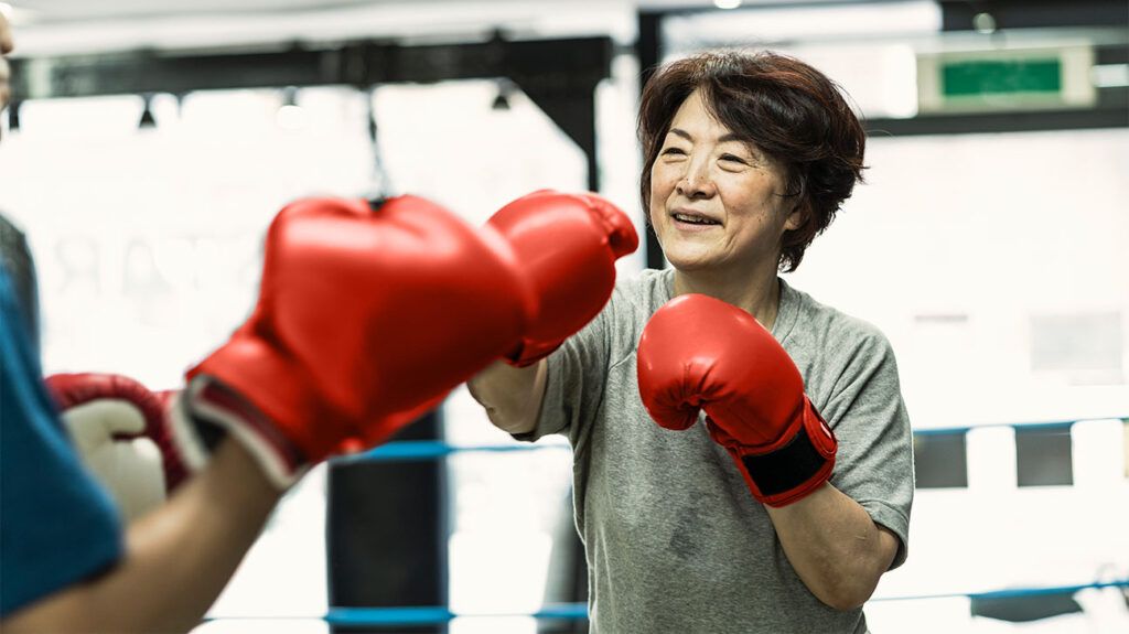 Older female boxing in a gym