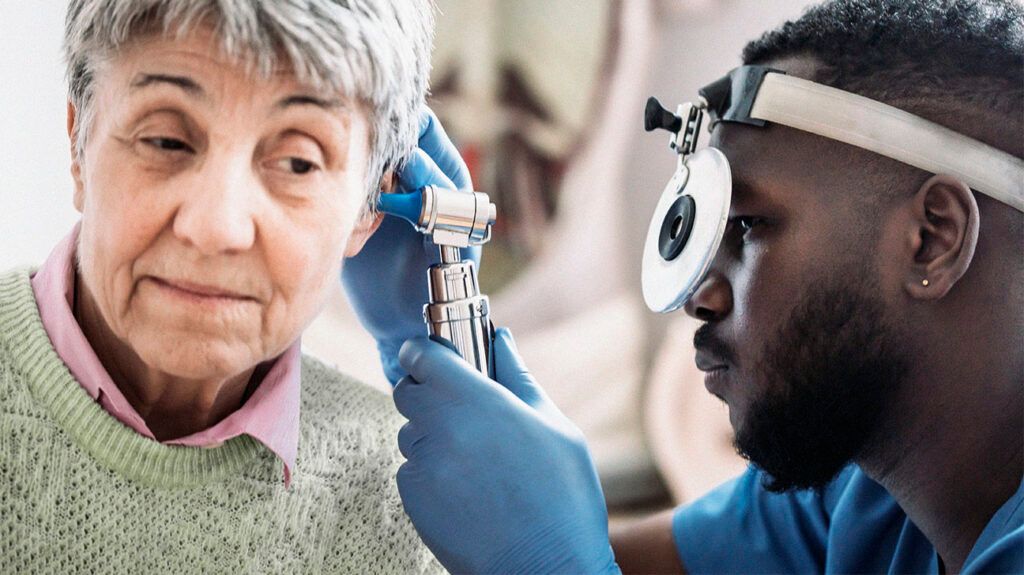 An older adult with tinnitus getting an ear exam from a doctor.-2