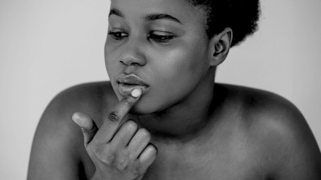 A person touching their lips, black and white image