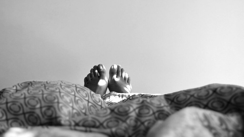 Photo of a person's feet in bed.