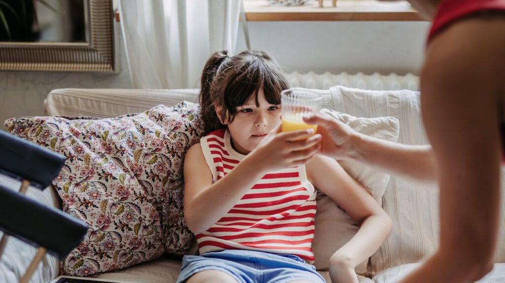 A child drinking fruit juice, which can help with A child with hypoglycemia.
