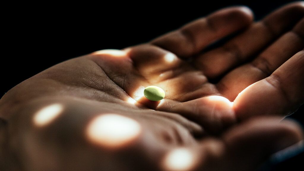 A pill in the palm of a person's hand