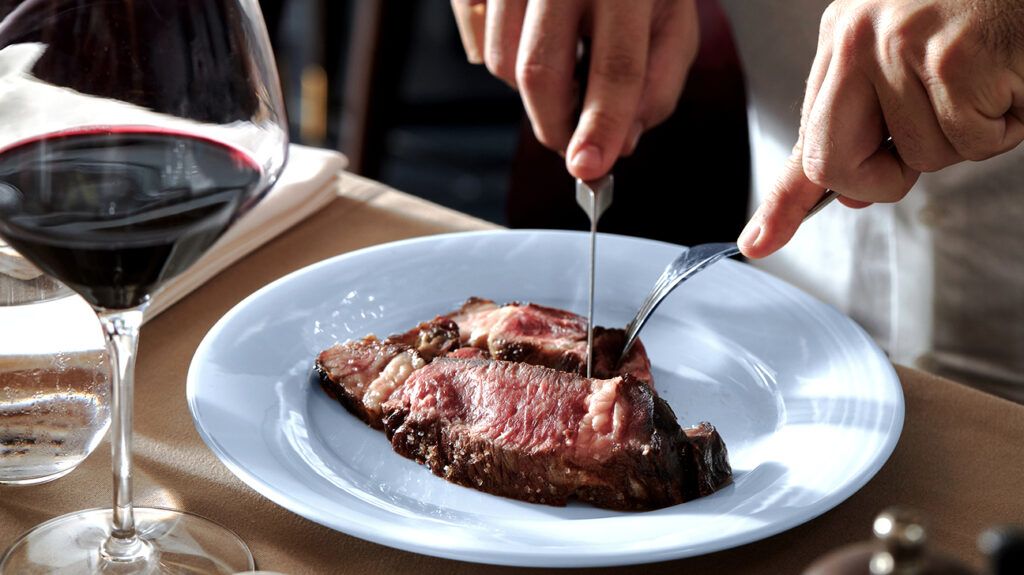 Person cutting into a steak