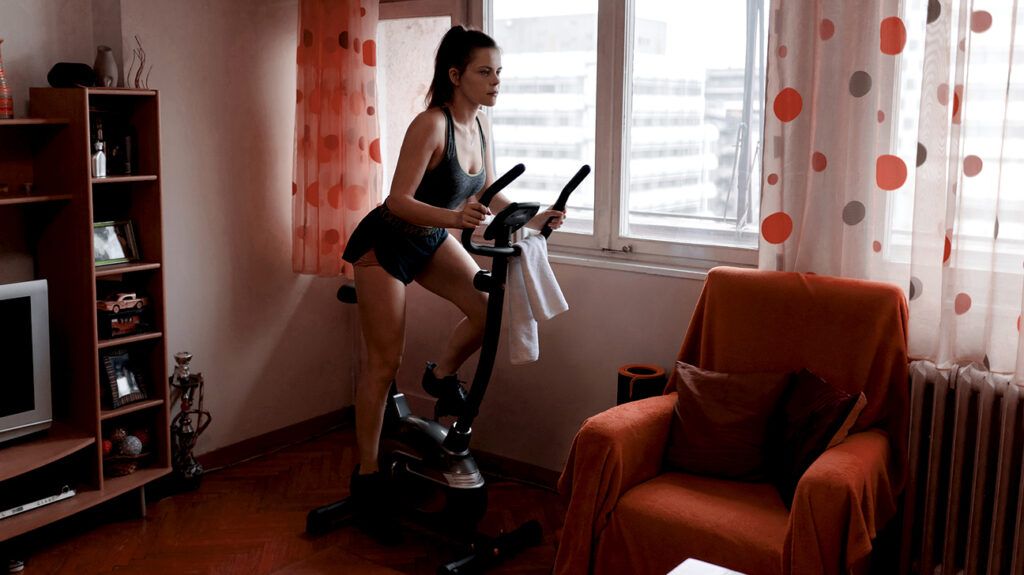 Female on an exercise bike in a living room