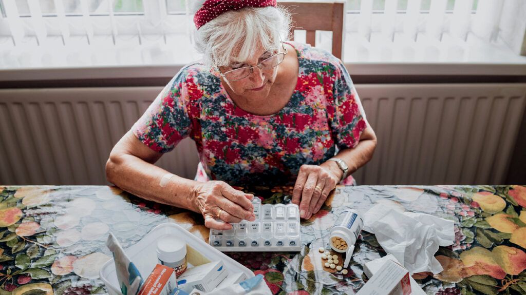 An older person organizing medications 1