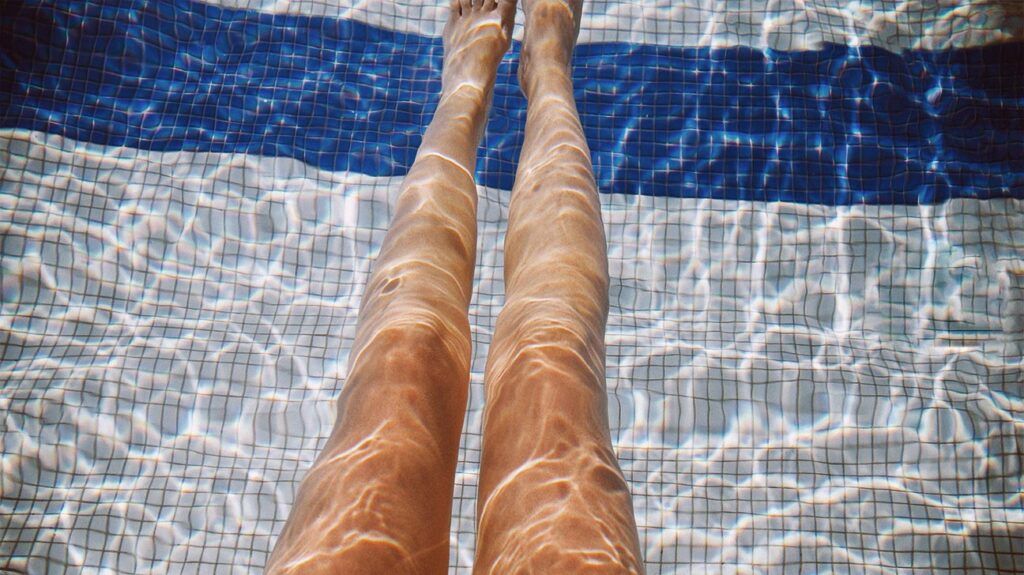 Female legs in the pool water-1