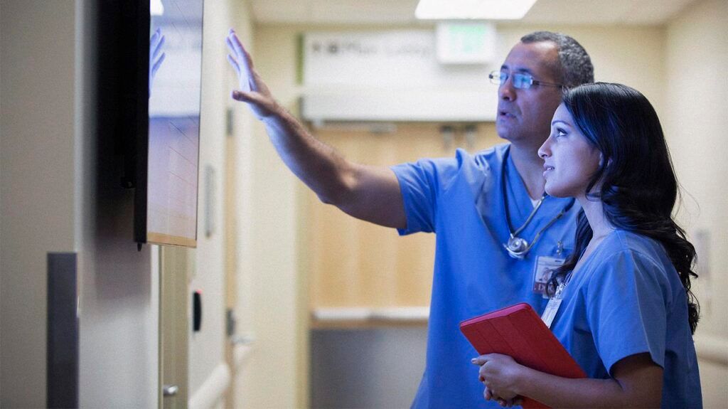 Two healthcare professionals looking at a monitor 1