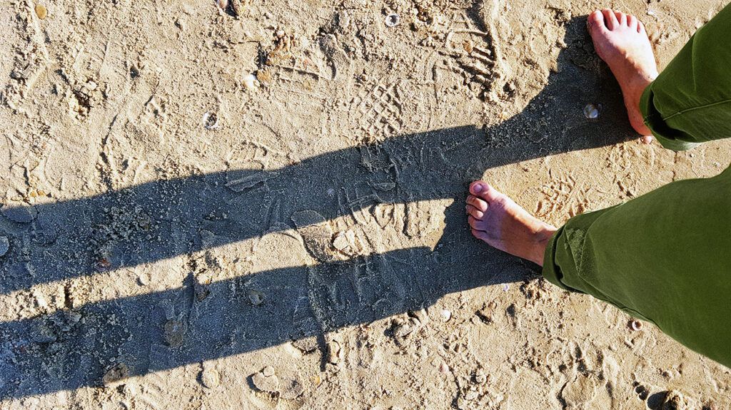 Shadows of a child's legs against the sand -2.