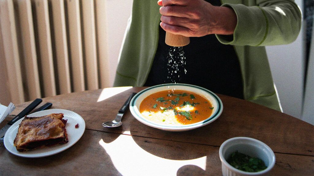 A person seasoning a soup full of fiber.-2