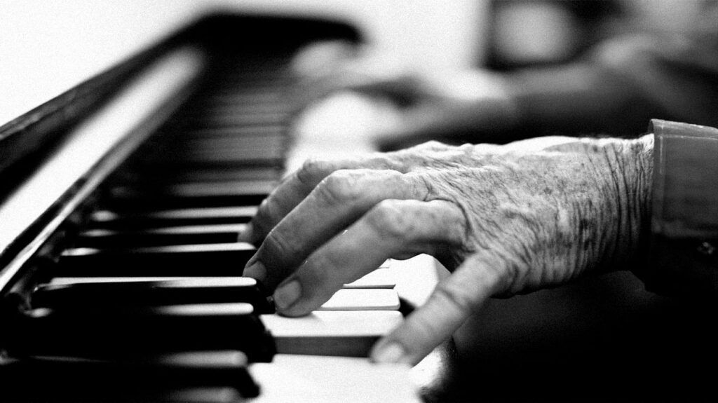 Older person's hands playing the piano