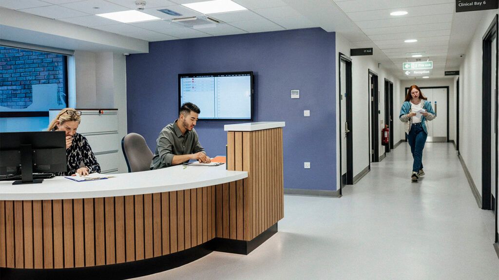 Man sitting at a hospital reception desk-1