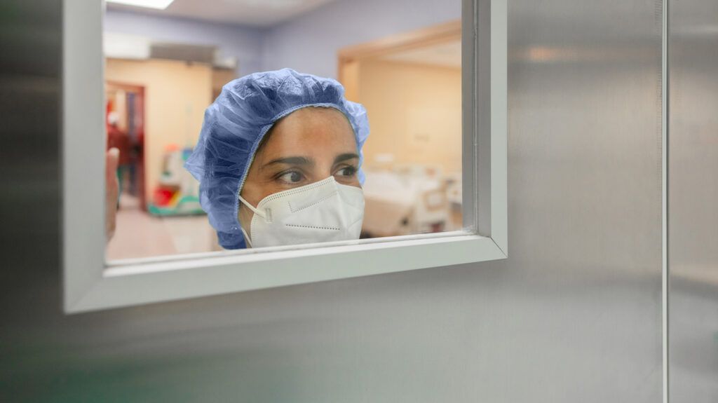 A surgeon looking through a glass door-1.