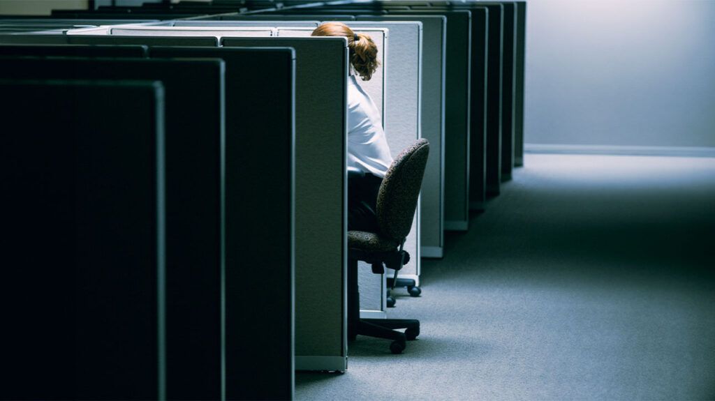 Person working in a cubicle in an empty office