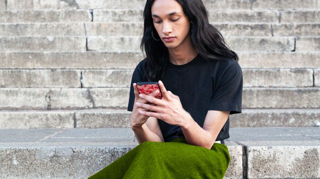 Person sitting on steps outside using their phone
