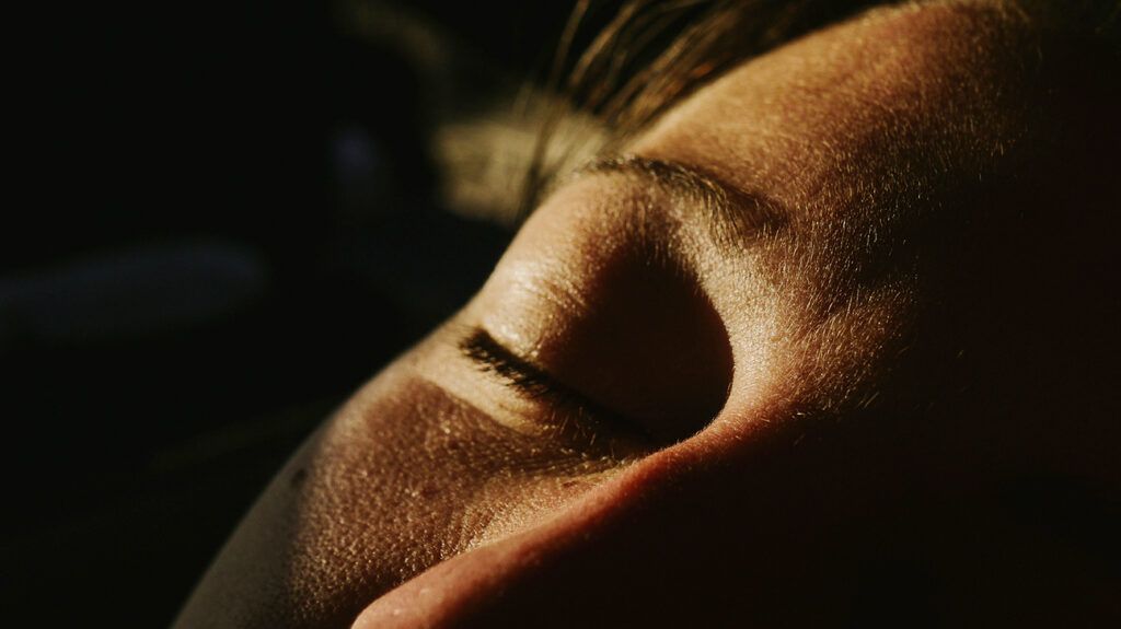 Closeup of a person with their eye closed.