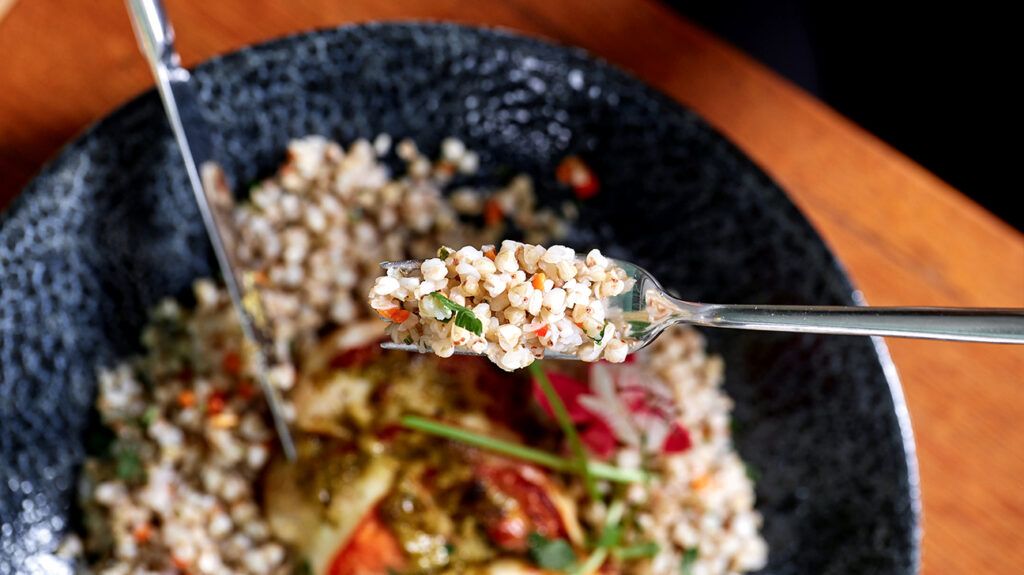 There is quinoa on a fork.