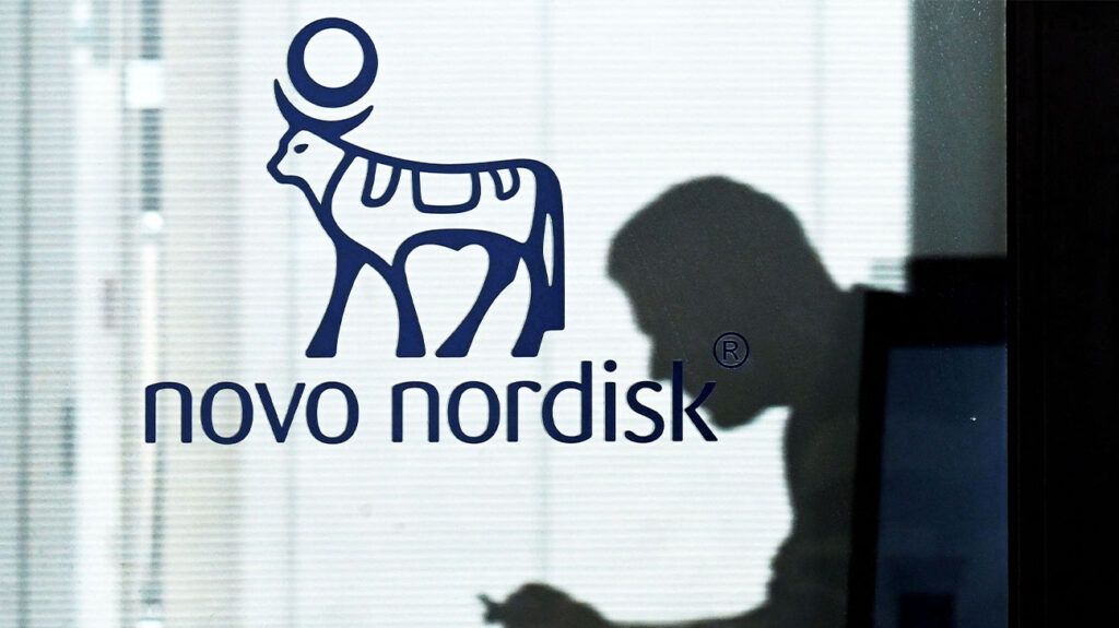 man's silhouette behind glass panel with Novo Nordisk branding