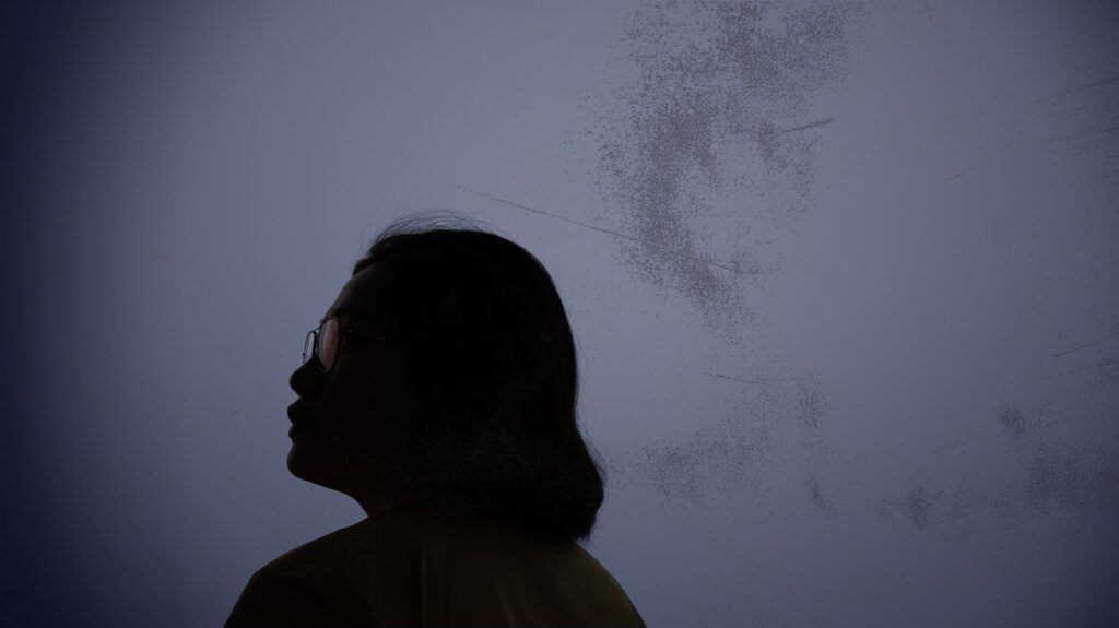 The silhouette of a woman with glasses