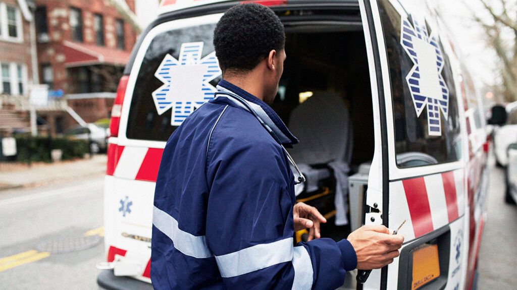 A paramedic opening the door of an ambulance.