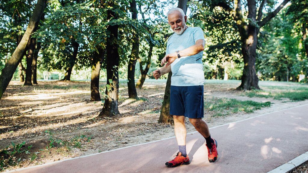 Senior man checking his pace while jogging
