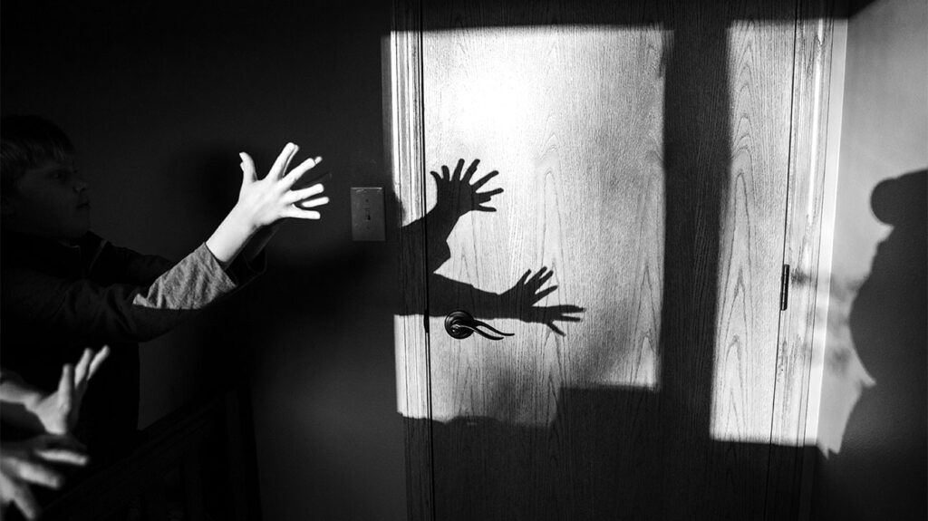 Children display hand shadow puppets on a wall