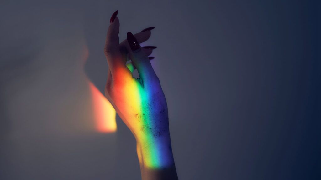 The hands of a person with eczema with a rainbow light over them.-1