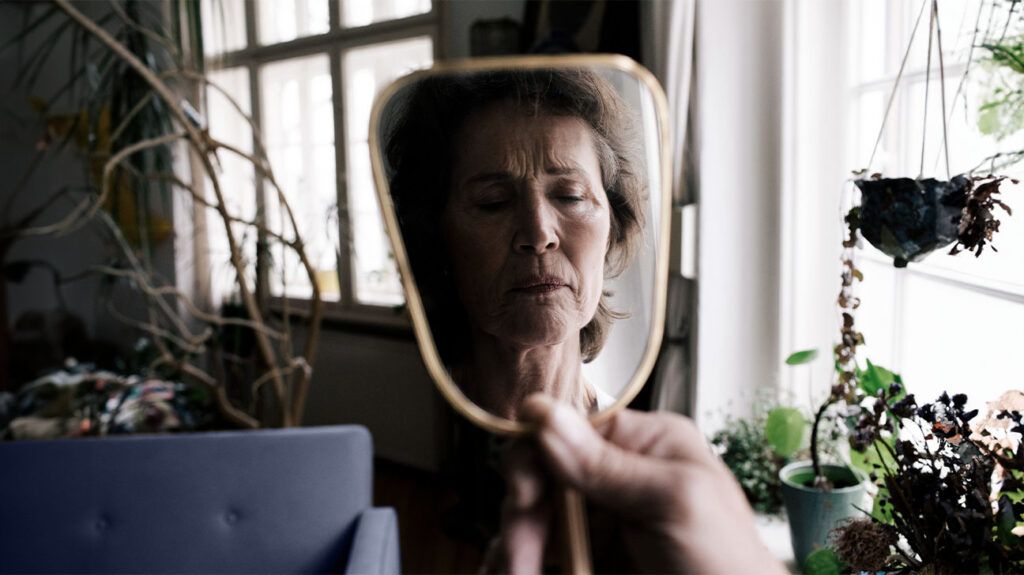 Older female's reflection in a hand held mirror
