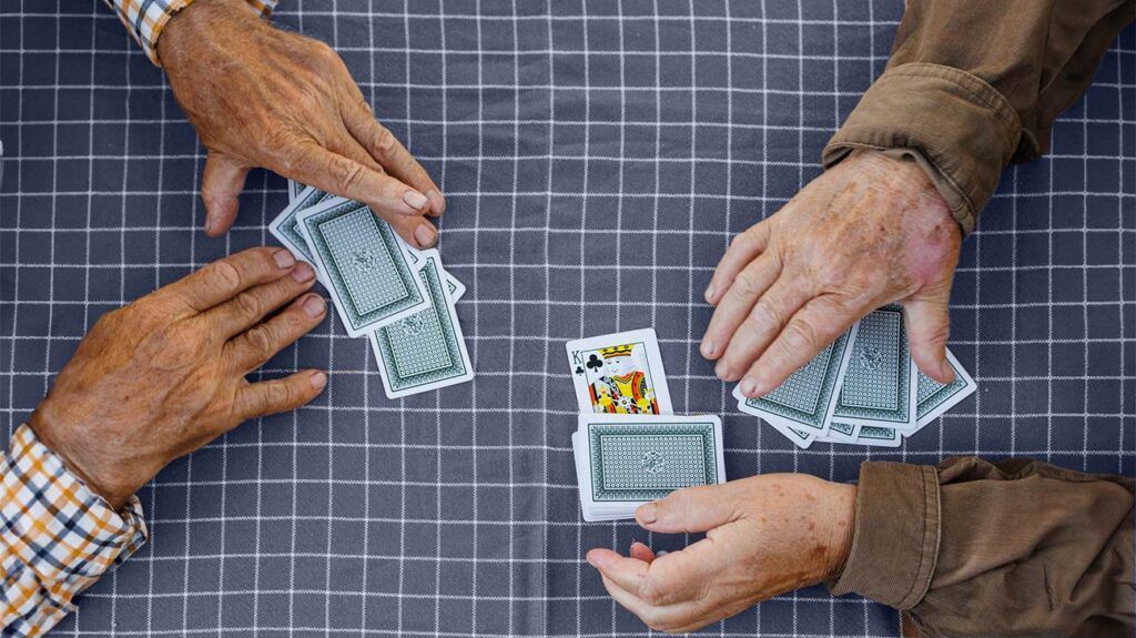 Two older men play a game of cards