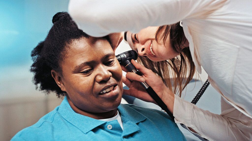 A person getting their ear checked for infection. -2