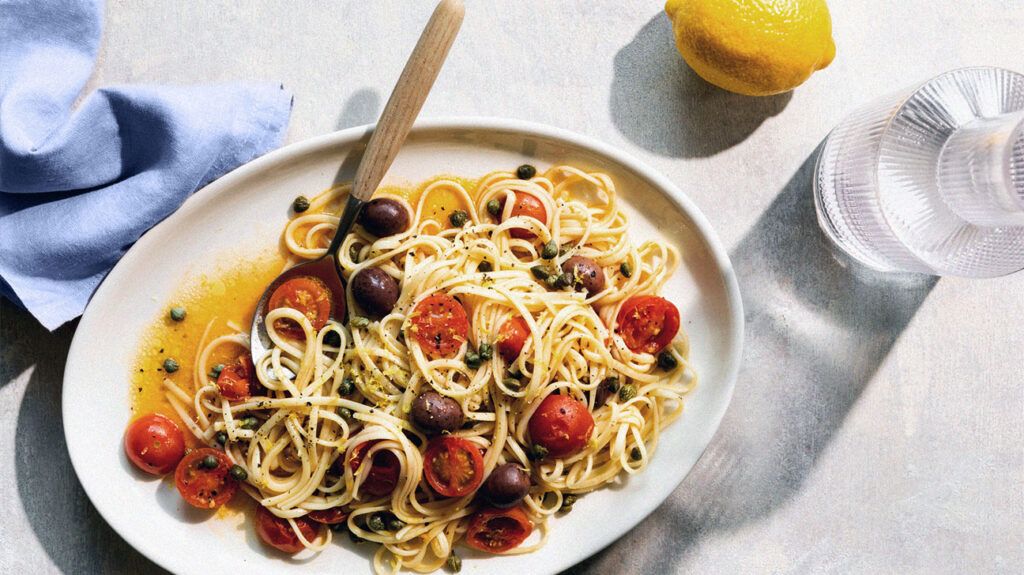 plate of spaghetti with cherry tomatoes and black olives