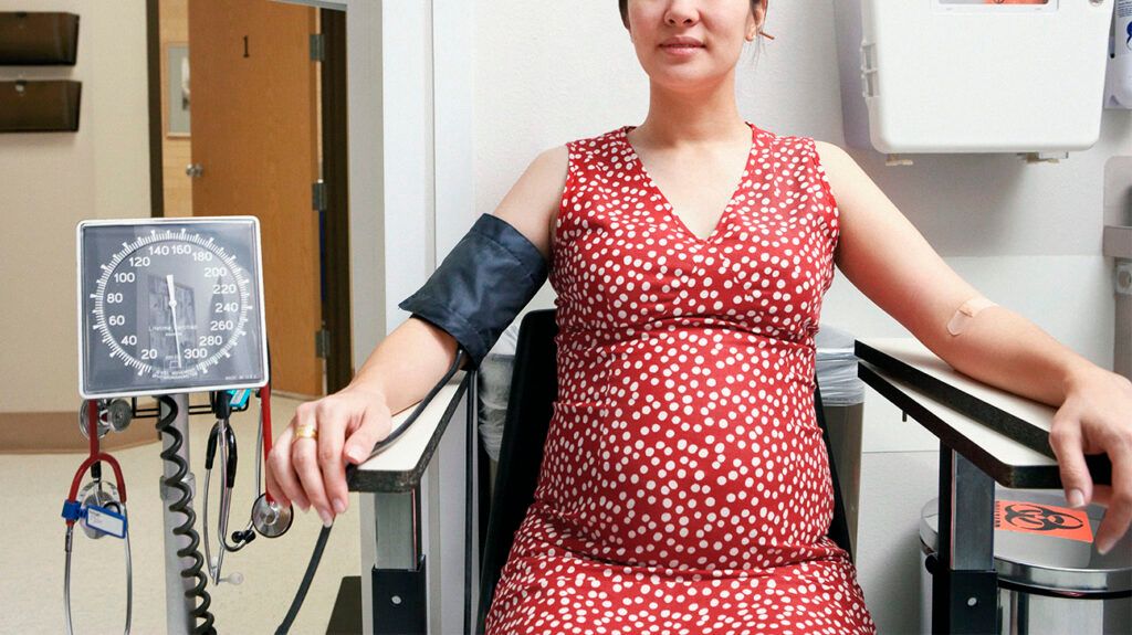 Pregnant person having their blood pressure checked