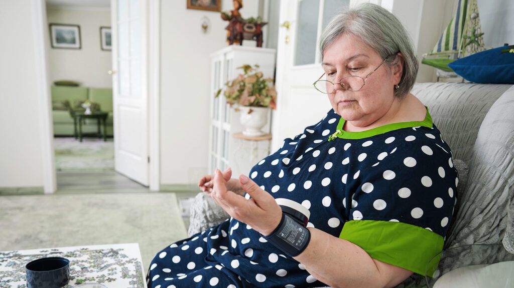 Older female checking her blood pressure at home
