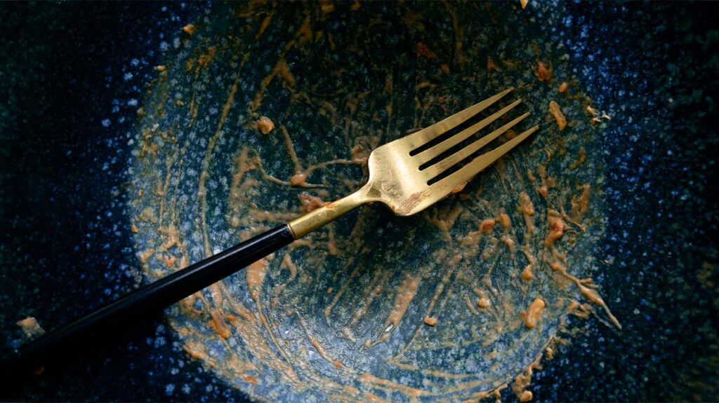 fork resting on empty blue plate
