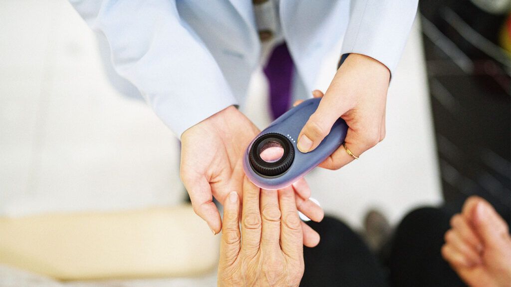 Healthcare professional examining a person's nails
