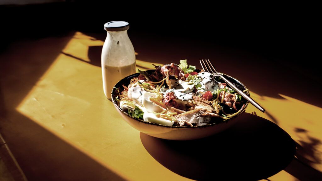 bowl of salad and small bottle with a dairy drink