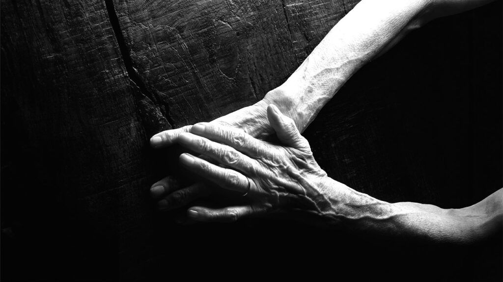 An old person's hands on a flat surface