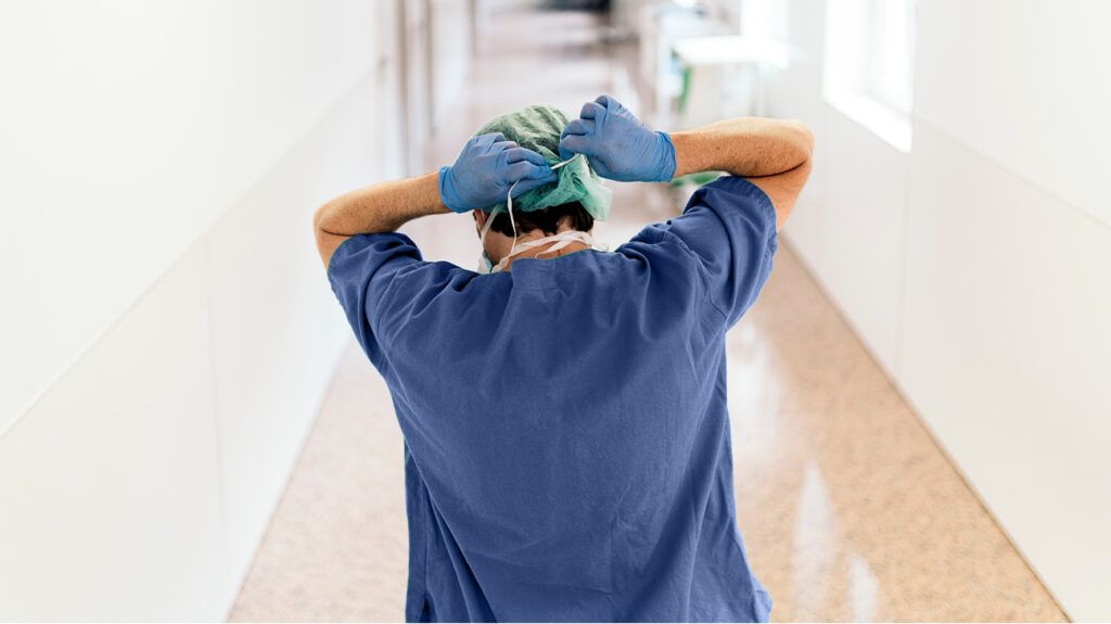 Surgeon walking down a corridor tying their head covering