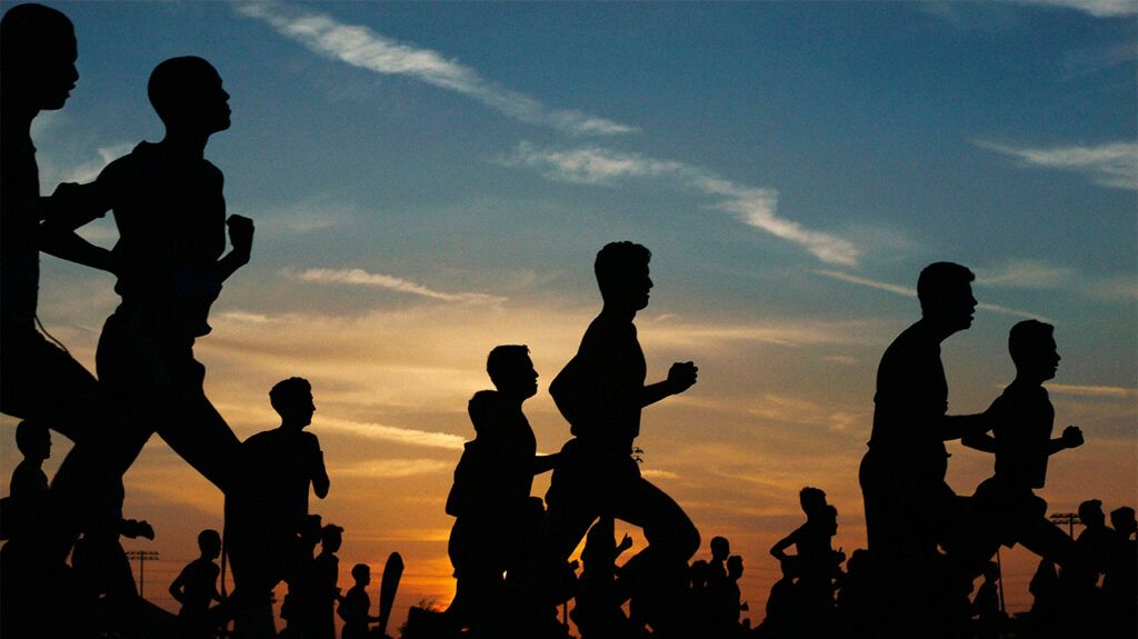 The silhouettes of runners at sunset