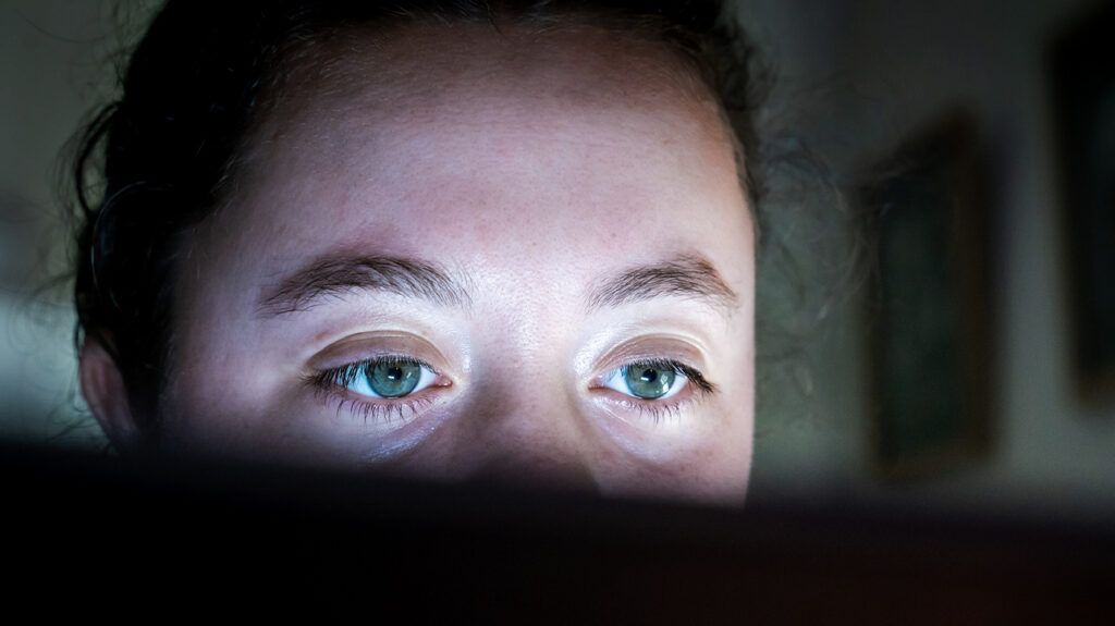 A woman's eyes reflected in the light of a computer screen. -2