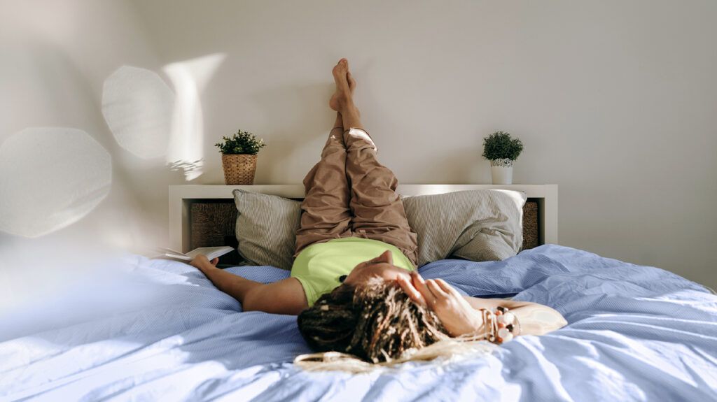 A person experiencing signs of a depression relapse lying on their back in bed.-2