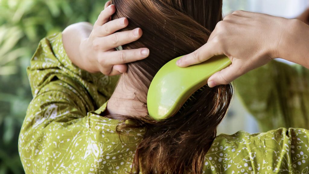 A woman brushing her long, brown hair.