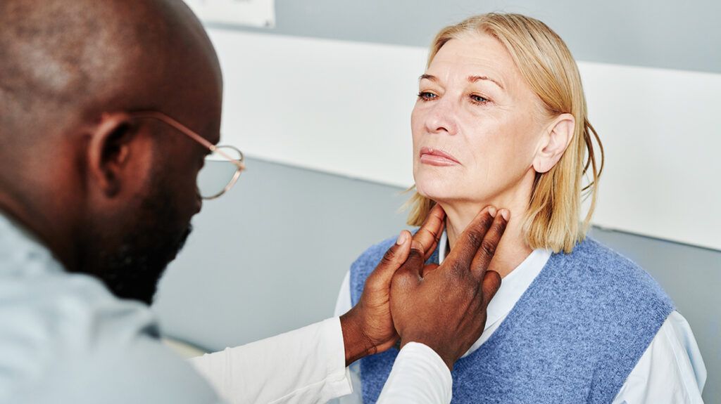 A doctor is examining a person's throat.