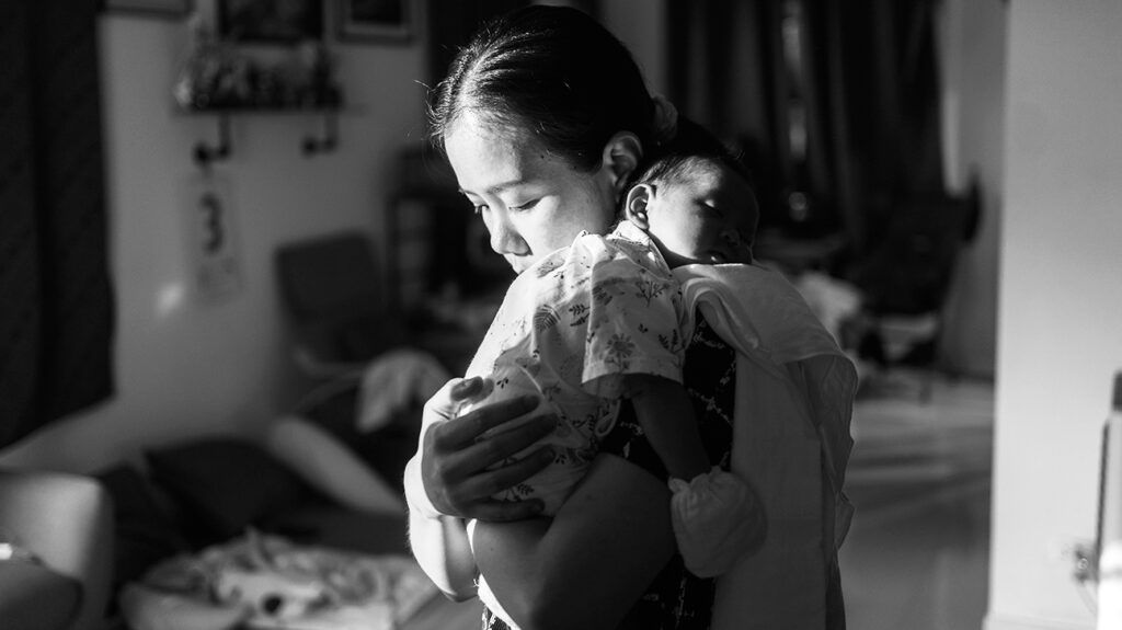 Black and white image of a female holding a baby