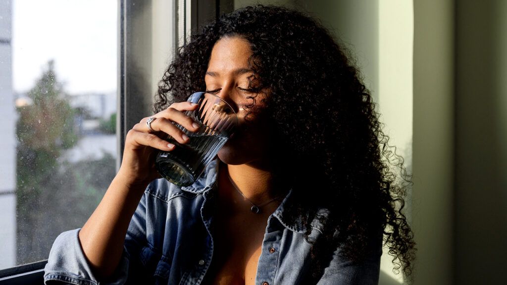 A woman drinking water to help soothe a dry throat -1.