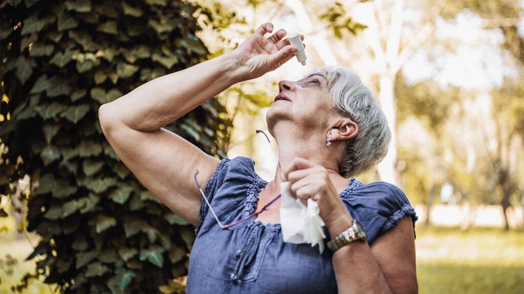 A person with Sjögren disease applying eye drops