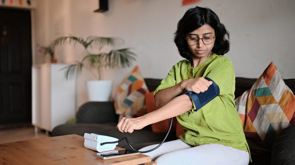 Female checking her blood pressure at home