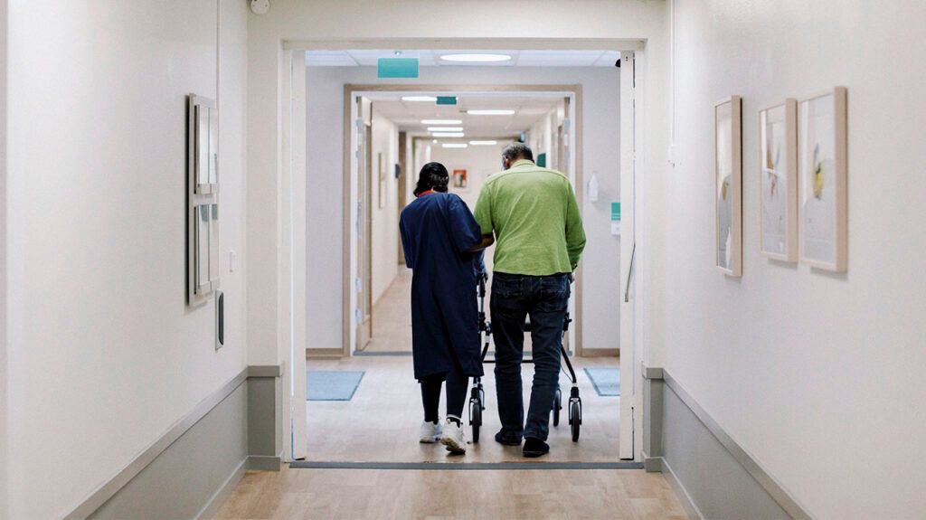 A nurse helping a person with Alzheimer's disease walk around an assisted living facility -2
