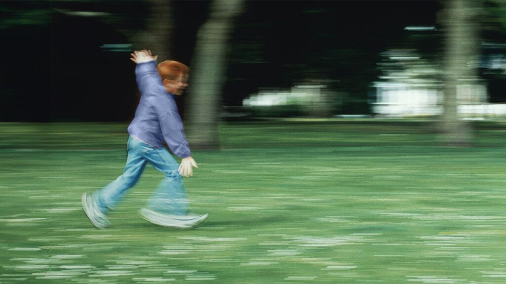 Blurred image of a child running through a park